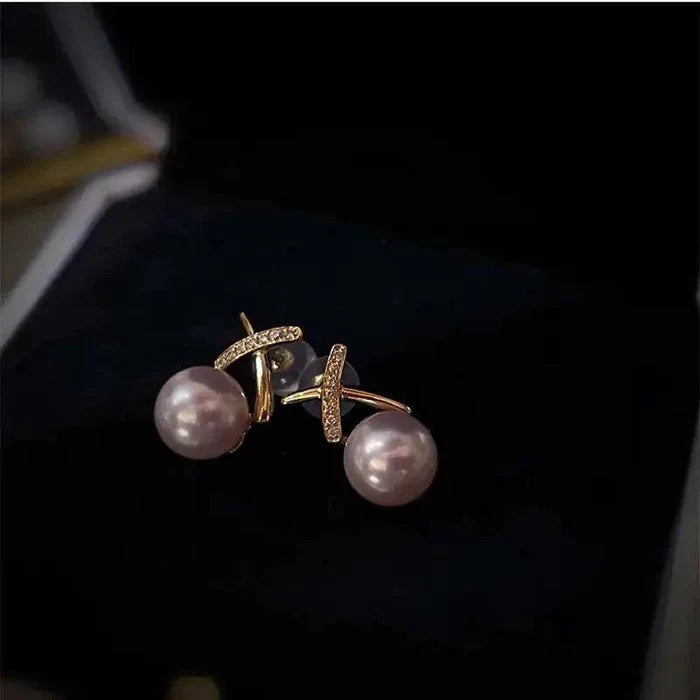 18K gold pearl stud earrings by MANDOTOS featuring elegant round white pearls and a classic, sophisticated design.