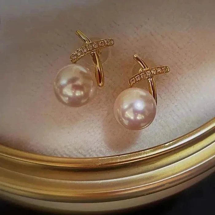 18K gold pearl stud earrings by MANDOTOS featuring elegant round pearls on classic gold posts.