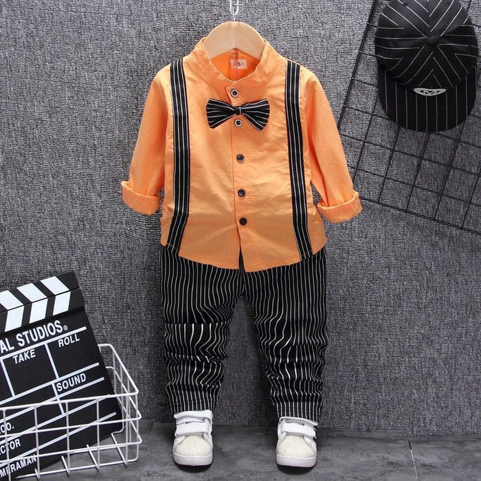 Orange kids shirt with black suspenders, striped pants, bow tie & white sneakers — stylish toddler outfit