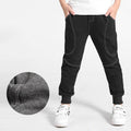 Boy wearing Ancient Energy boys' sports trousers, showing the athletic fit and breathable fabric in action.