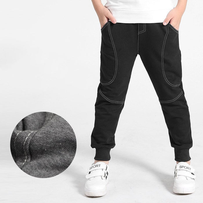 Boy wearing Ancient Energy boys' sports trousers, showing the athletic fit and breathable fabric in action.