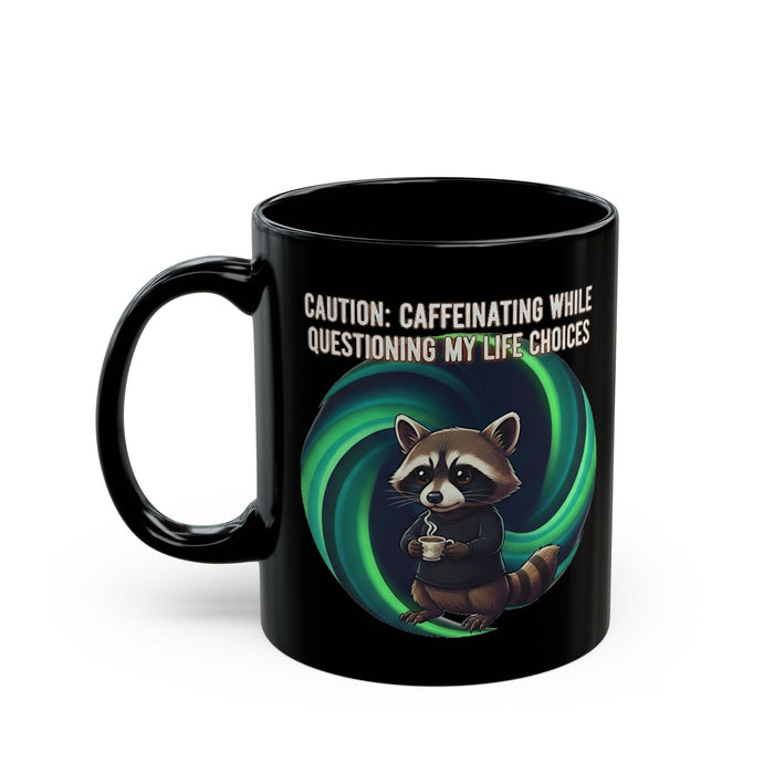 Black mug with a raccoon holding a cup and text 'Caution: Caffeinating while questioning my life choices' on a white background.