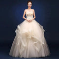 Elegant one-shoulder bridal gown by MANDOTOS INTERNATIONAL featuring flowing fabric and intricate details for special occasions.