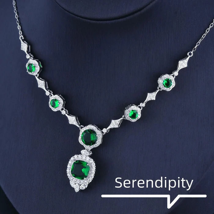 Mandotos Emerald Elegance white gold necklace featuring a central emerald gemstone and delicate chain design.