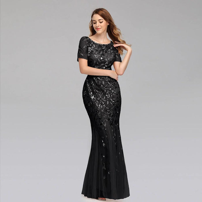Elegant black evening dress by MANDOTOS featuring a floor-length design and subtle satin finish.