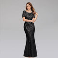 Elegant black evening dress by MANDOTOS featuring a fitted bodice and flowing skirt, perfect for formal occasions.