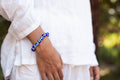 Ancient Energy Evil Eye Protection Bracelet featuring blue and white beads on a leather cord for warding off negative energy.