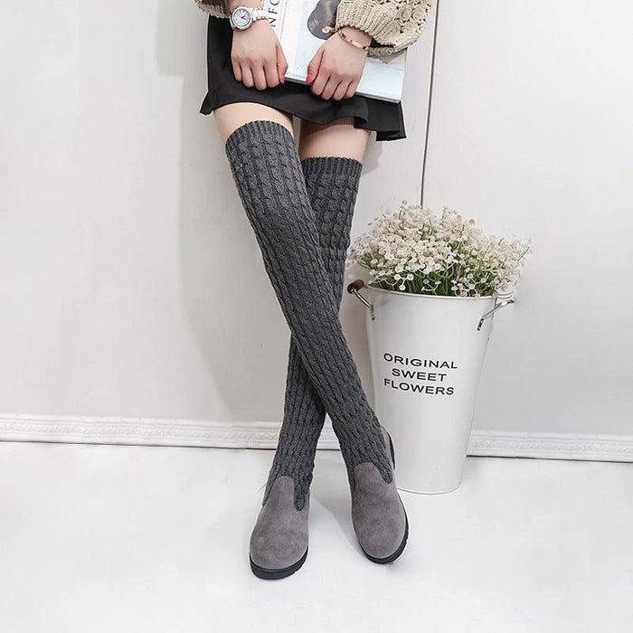 Black high flat over-the-knee stretch Martin boots from MANDOTOS with a sleek, fitted design and flat sole, perfect for stylish winter wear.