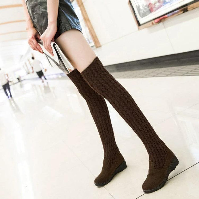 Mandotos high flat over-the-knee stretch Martin boots in black leather, featuring a sleek, fitted design with flat soles.