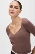 Woman in brown long-sleeve V-neck top, stylish fashion apparel
