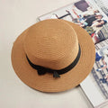 Mandotos Island Breeze Boater hat in natural straw with a wide brim and black ribbon for sun protection and stylish summer wear.