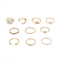 Mandotos bohemian star, moon, pearl, and leaf 10-piece gold finish ring set with stackable designs on a white background.