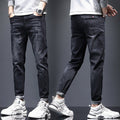 Men's ripped denim jeans with cat-whisker scratches by Ancient Energy, showing distressed denim with stylish, intentional tears and scratches.
