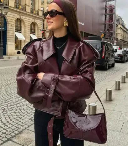 Mandotos sleek matte leather coat displayed on a hanger, showcasing its smooth texture and modern design.